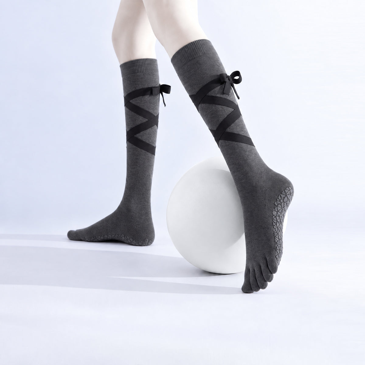 Non-slip, strappy, over-the-calf toe socks for yoga and Pilates.