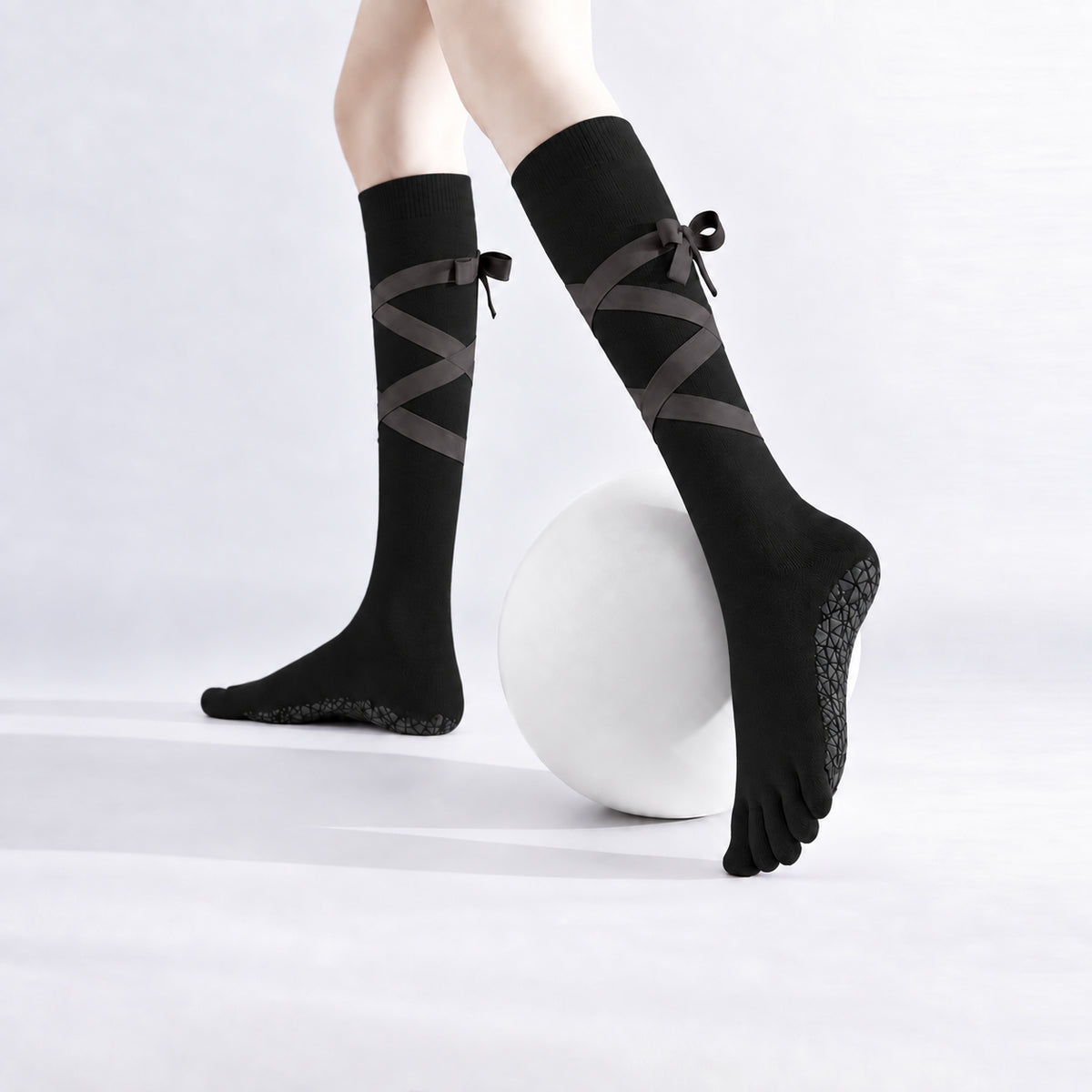 Non-slip, strappy, over-the-calf toe socks for yoga and Pilates.